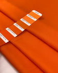 Silk with polyester and viscose in a very bright orange. The fabric is structured. High-quality deadstock fabric collected in Stock from a Maison de Couture in Italy.