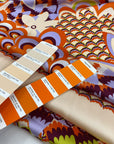Printed polyester twill in panels. The ground is light peach and the print is in shades of bright orange, lilac, and green. Very flowy, a little shiny. High-quality deadstock collected in Stock from a Maison de Couture in Italy.