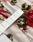 Polyester satin printed with a large floral design in shades of green, red, and fuchsia on an ivory background. Very soft and light, flowy, and ideal for dresses, blouses, shirting, and skirts. High-quality deadstock collected in Stock from a Maison de Couture in Italy.