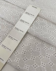 Pure cotton in bright white with geometric square embroidery. Very soft, light, and slightly transparent. Perfect for shirting, dresses, and skirts. High-quality deadstock collected in Stock from a Maison de Couture in Italy.