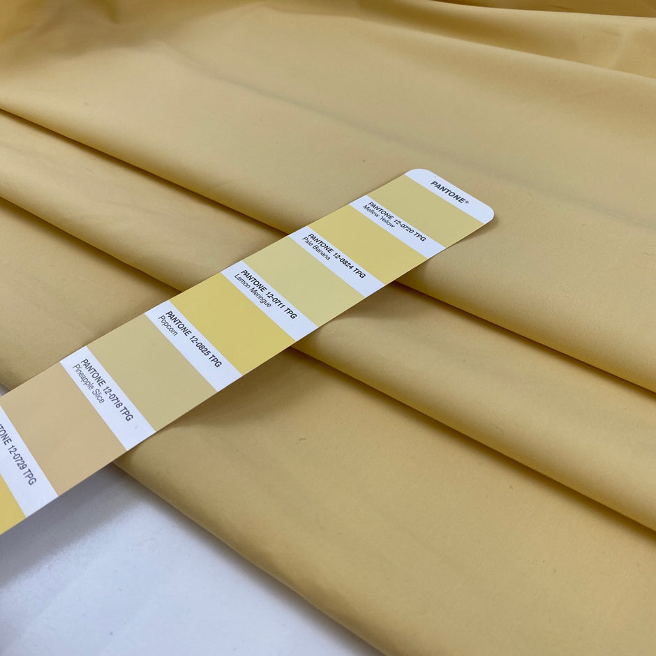 Cotton polyester fabric in pale banana yellow, very crunchy, light, and not transparent, ideal for shirts, dresses, and structured pieces. High-quality deadstock collected in Stock from a Maison de Couture in Italy.