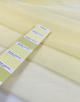 Polyester stretch tulle in light yellow color reference Tender Yellow. Very soft, light, and transparent, it adds volume and is ideal for dresses and skirts. High-quality deadstock collected in Stock from a Maison de Couture in Italy.