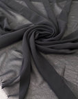 Polyester georgette in black. Very light, soft, and flowy with transparent finish. Ideal for shirting, dresses, and skirts. High-quality deadstock collected in Stock from a Maison de Couture in Italy.