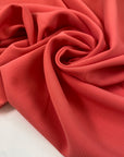 Polyester cady in calypso coral, very soft, flowy and with a matte finish. Ideal for trousers, skirts, dresses and jackets. High-quality deadstock collected in Stock from a Maison de Couture in Italy.