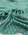 Very soft, smooth, and light polyester satin with a small geometric design in shades of light blue, green, and pink. Not transparent. High-quality deadstock collected in Stock from a Maison de Couture in Italy.