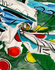 Light and soft polyester twill with a white base and large multicolor print in shades of red, yellow, black, green, and light blue. Ideal for dresses, skirts, blouses, and shirting. High-quality deadstock collected in Stock from a Maison de Couture in Italy.