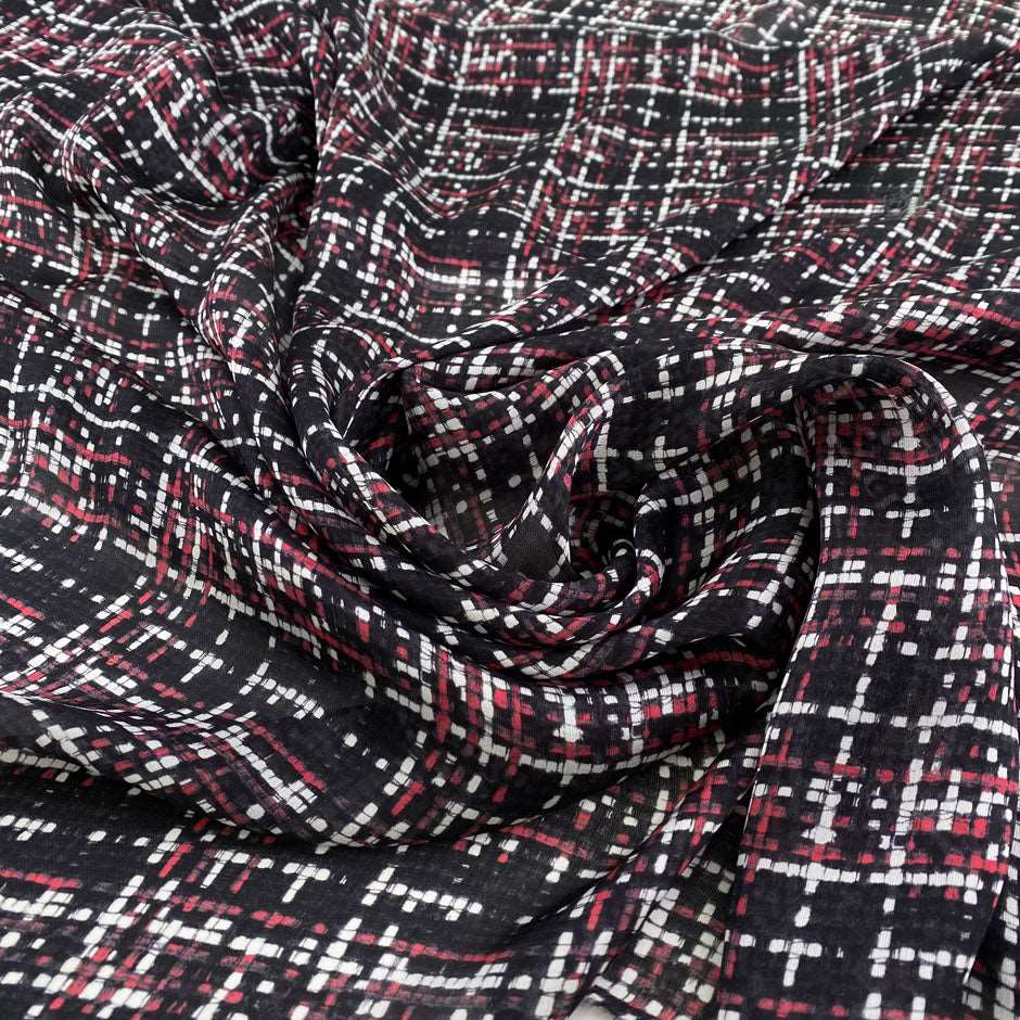 Silk charmeuse fabric, transparent, soft and droopy with a red, black and white geometric print. High quality deadstock fabric collected in Stock from a Maison de Couture in Italy.