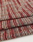 Red, black, orange and white cotton blend tweed. The fabric feels droopy and heavy. High quality deadstock fabric. 