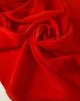 Crepe de chine in red color reference flame scarlet. Very soft and light, flowy and not transparent. Ideal for dresses, skirts, blouses, and shirting. High-quality deadstock collected in Stock from a Maison de Couture in Italy.