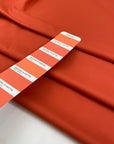 Light and soft waterproof polyester cinzato with elastane in orange, ideal for windbreakers, trenches, and light outerwear. High-quality deadstock collected in Stock from a Maison de Couture in Italy. 