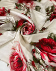 Polyester satin printed with a large floral design in shades of green, red, and fuchsia on an ivory background. Very soft and light, flowy, and ideal for dresses, blouses, shirting, and skirts. High-quality deadstock collected in Stock from a Maison de Couture in Italy.