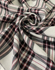 Soft and flowy polyester and viscose fabric with a check design in shades of gray and black, accented by subtle red stripes. Ideal for jackets, trousers, skirts, and dresses. High-quality deadstock collected in Stock from a Maison de Couture in Italy.