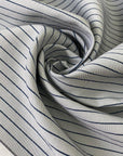 Heavy taffeta in a mix of polyester, silk, and cotton. Gray ground with blue stripes, heavy and stiff. Ideal for structured jackets, dresses, or skirts. High-quality deadstock collected in Stock from a Maison de Couture in Italy.