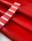 Vinyl fabric in flame red, very stiff in cotton and polyester. High-quality deadstock fabric by the meter collected in Stock from a Maison de Couture in Italy.