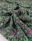 Viscose and wool crepe with a beautiful small flower design, the ground is green and the flowers are in white, fuchsia, and black shades. It is very soft and light. High-quality deadstock fabric by the meter collected in Stock from a Maison de Couture in Italy.