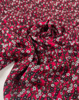 Viscose and wool with a beautiful small flower design, the ground is raspberry and the flowers are in green, white, gray, and black shades. It is very soft, light and warm. High-quality deadstock fabric by the meter collected in Stock from a Maison de Couture in Italy.