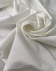White cotton with elastane in cloudy dancer shade medium weight slightly stiff with striped texture ideal for skirts trousers and jackets. High-quality deadstock collected in Stock from a Maison de Couture in Italy.