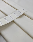 Stretch cotton gabardine in neutral white. Structured and solid. High-quality deadstock collected in Stock from a Maison de Couture in Italy.