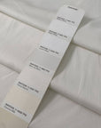 White cotton with elastane in cloudy dancer shade medium weight slightly stiff with striped texture ideal for skirts trousers and jackets. High-quality deadstock collected in Stock from a Maison de Couture in Italy.