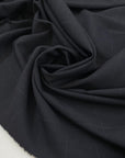 Wool mixed with polyester and elastane featuring a check design in dark blue. Very soft, light, flowy, and not transparent. Ideal for trousers, skirts, and jackets. High-quality deadstock collected in Stock from a Maison de Couture in Italy.