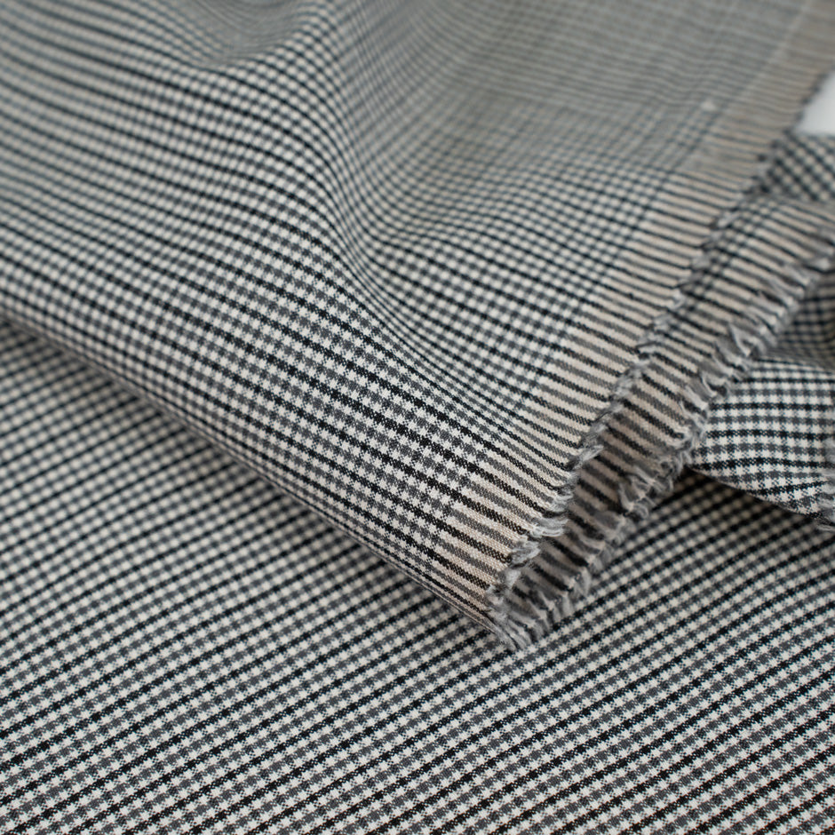 Gray checkered wool and polyester. The fabric is elastic and falling. High-quality deadstock fabric collected in Stock from a Maison de Couture in Italy.