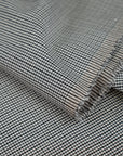 Gray checkered wool and polyester. The fabric is elastic and falling. High-quality deadstock fabric collected in Stock from a Maison de Couture in Italy.