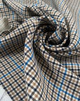 Mixed polyester comfort stretch, with checked design in the shades of beige, color reference natural, and turquoise, color reference fiod blue. A little heavy and flowy, ideal for trousers and jackets. High-quality deadstock collected in Stock from a Maison de Couture in Italy.