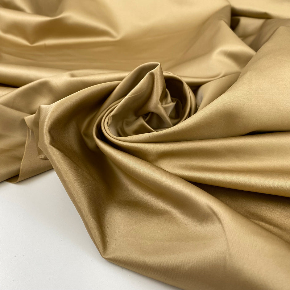 Polyester satin in beige sand very soft and shiny, not transparent and flowy. High-quality deadstock fabric collected in Stock from a Maison de Couture in Italy.