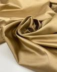 Polyester satin in beige sand very soft and shiny, not transparent and flowy. High-quality deadstock fabric collected in Stock from a Maison de Couture in Italy.