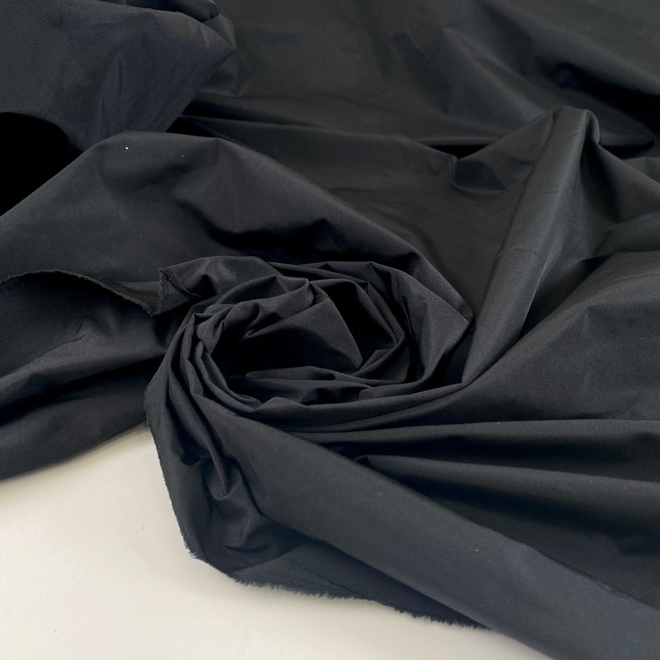 Very light black polyester taffeta with a crisp crunchy texture ideal for structured garments and voluminous shapes. High-quality deadstock collected in Stock from a Maison de Couture in Italy.