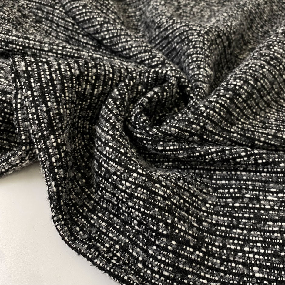 Tweed in polyester wool and viscose blend in smoked pearl grey. Very soft, light, warm and flowy. Ideal for winter dresses, jackets, skirts and light coats. High-quality deadstock collected in Stock from a Maison de Couture in Italy.