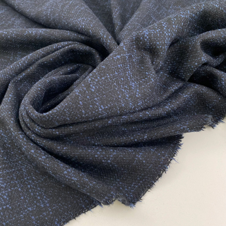 Blue virgin wool blend melange tweed. The fabric feels textured and heach of texture. High quality deadstock fabric.