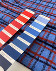 Pure wool twill with check pattern in blue red and dark blue shades blue jasper and molten lava soft and warm ideal for jackets light coats and winter skirts. High-quality deadstock collected in Stock from a Maison de Couture in Italy.