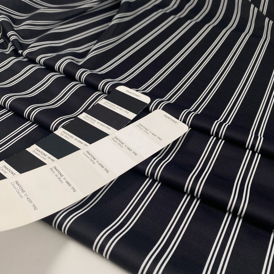 Black base Punto Milano polyester with double white lines. The fabric is stretch. High-quality deadstock collected in Stock from a Maison de Couture in Italy.