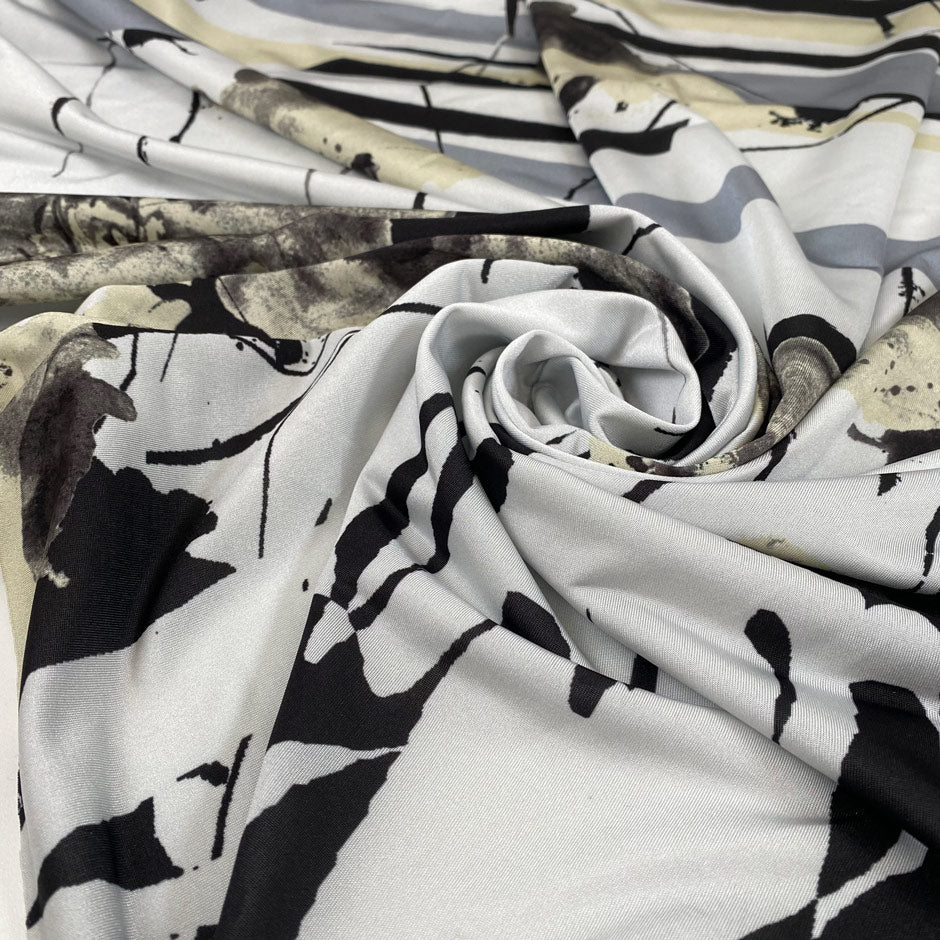 Polyester jersey in abstract design in white, sand, beige, black and gray shades. Very soft, flowy and stretch. High-quality deadstock fabric collected in Stock from a Maison de Couture in Italy.