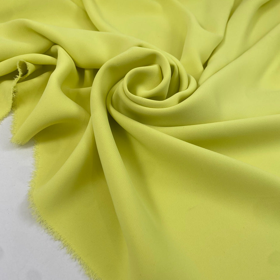 Polyester cady in bright yellow, color reference Sunny Lime. Very soft, light, and flowy, not transparent. Ideal for trousers, dresses, and skirts. High-quality deadstock collected in Stock from a Maison de Couture in Italy.