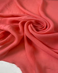 Light and soft viscose georgette in a coral shade. Slightly transparent with an elegant drape, perfect for skirts, blouses, shirting, and dresses. High-quality deadstock collected in Stock from a Maison de Couture in Italy.