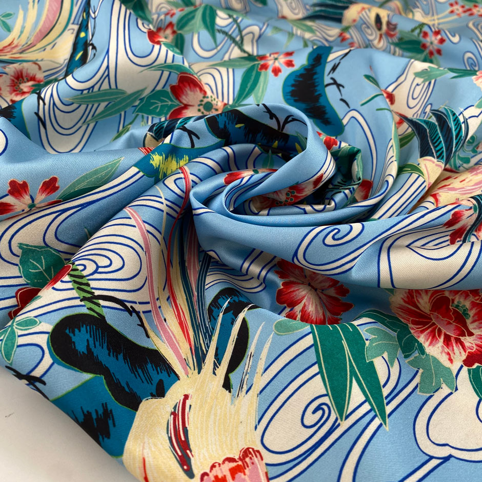 Polyester satin with floral design in the shades of blue, white, light blue, green and red. Very soft, light and flowy. High-quality deadstock fabric collected in Stock from a Maison de Couture in Italy.