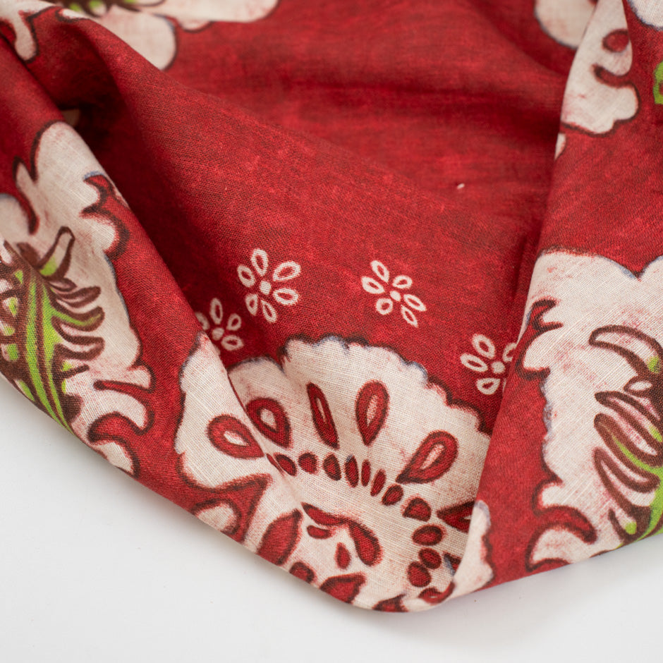 Red-based and printed linen and cotton. The fabric has a floral and structured design. High-quality deadstock fabric collected in Stock from a Maison de Couture in Italy.