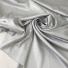 Polyester satin in light gray, Glacier Gray. Very soft, light, shiny and flowy, not transparent. Ideal for dresses, skirts, blouses, and shirting. High-quality deadstock collected in Stock from a Maison de Couture in Italy.