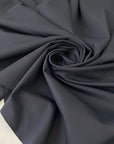 Stretch Lycra in dark gray color reference Ebony. Very soft, flowy, and ideal for swimsuits, shapewear, dresses, and skirts. High-quality deadstock collected in Stock from a Maison de Couture in Italy.