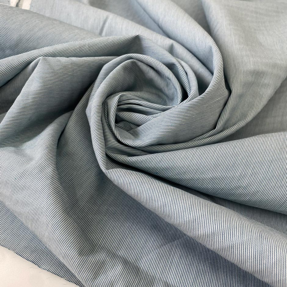 Stretch cotton fabric with a fine striped pattern in light blue. Very soft and light, ideal for shirts, dresses, and skirts. High-quality deadstock collected in Stock from a Maison de Couture in Italy.
