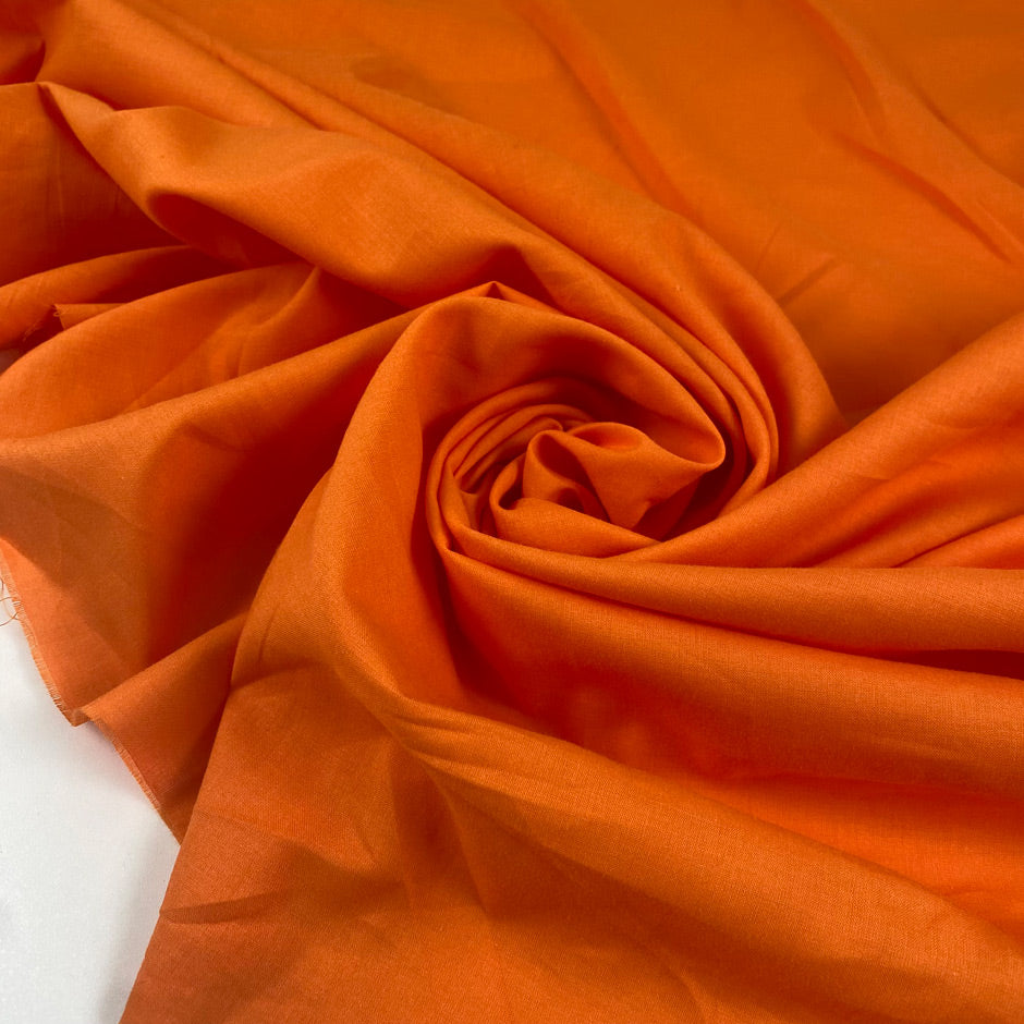 Pure cotton batiste in orange color reference Autumn Sunset. Very light and soft, not transparent. Ideal for summer dresses, skirts, blouses, and shirting. High-quality deadstock collected in Stock from a Maison de Couture in Italy.