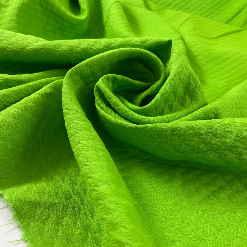 Pure cotton jacquard in green color reference Jasmine Green. Very soft and flowy, not transparent. Ideal for dresses, skirts, trousers, and jackets. High-quality deadstock collected in Stock from a Maison de Couture in Italy.