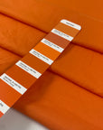 Pure cotton batiste in orange color reference Autumn Sunset. Very light and soft, not transparent. Ideal for summer dresses, skirts, blouses, and shirting. High-quality deadstock collected in Stock from a Maison de Couture in Italy.