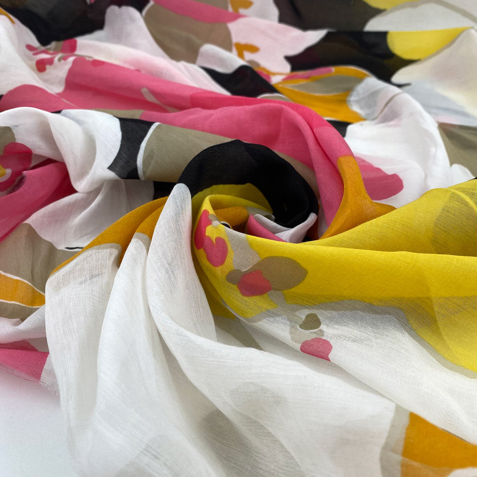 Cotton and silk chiffon with vast flower design in white, fuchsia, orange, yellow, and black shades. Very soft, light and transparent. High-quality deadstock fabric by the meter collected in Stock from a Maison de Couture in Italy.