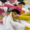 Cotton and silk chiffon with vast flower design in white, fuchsia, orange, yellow, and black shades. Very soft, light and transparent. High-quality deadstock fabric by the meter collected in Stock from a Maison de Couture in Italy.