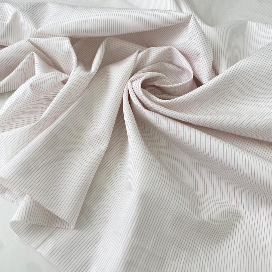 Pure cotton shirting fabric with a white ground and pale pink stripe. Very soft, light, and not transparent. Ideal for shirting and dresses. High-quality deadstock collected in Stock from a Maison de Couture in Italy.