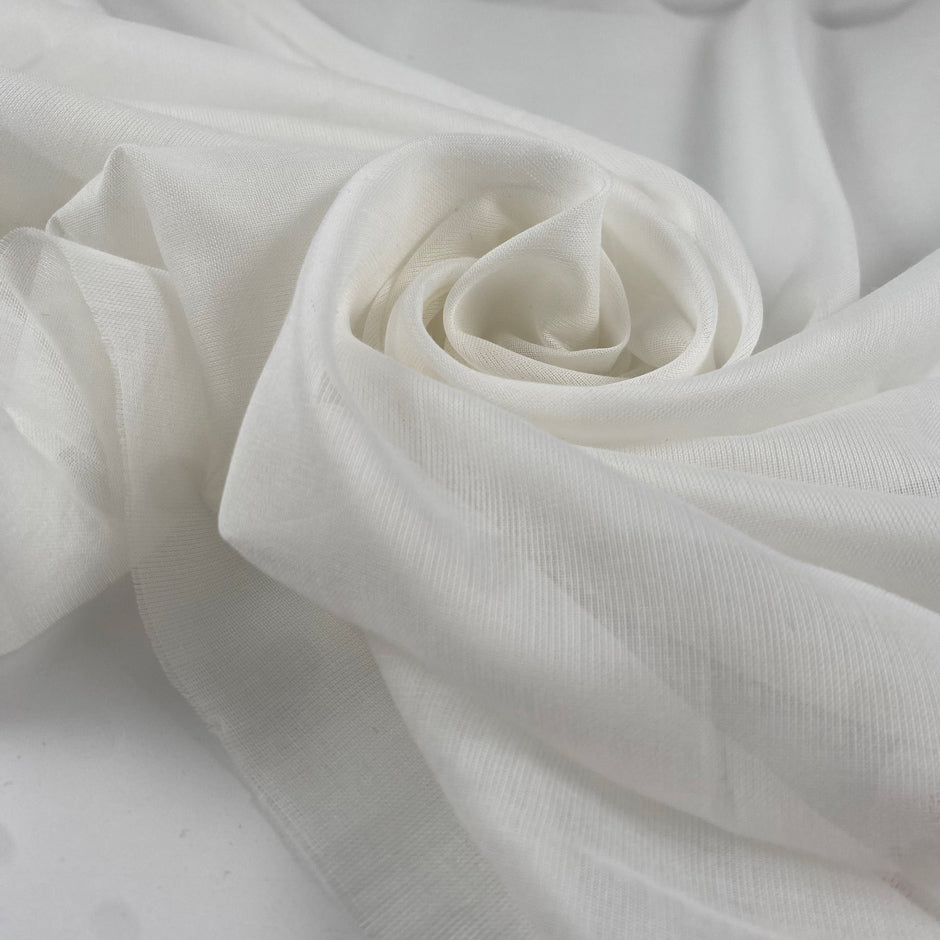 Pure cotton gauze in coconut milk white, very soft, light, and transparent. Flowy and breathable, ideal for dresses, shirting, and blouses. High-quality deadstock collected in Stock from a Maison de Couture in Italy.