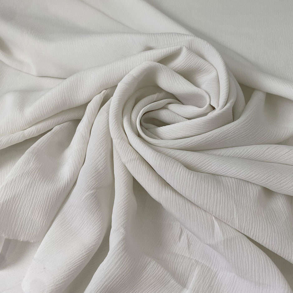 Very soft and light silk and acetate fabric with a crushed effect in white. Slightly transparent and flowy, perfect for blouses, shirting, dresses, and skirts. High-quality deadstock collected in Stock from a Maison de Couture in Italy.